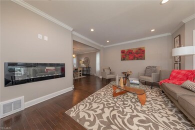 The warm and inviting Living Room with hardwood floor, crown molding and recessed lights