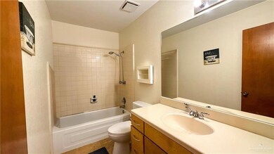 Full bathroom with toilet, shower / bath combination, visible vents, and vanity