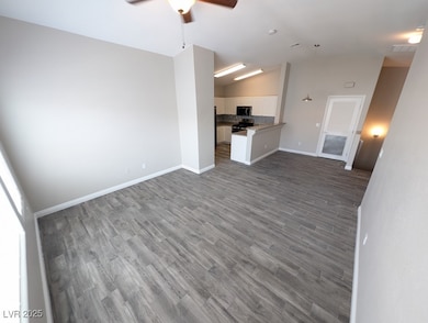 Unfurnished living room featuring a ceiling fan, v