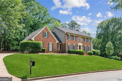 Colonial house featuring a front yard and brick siding