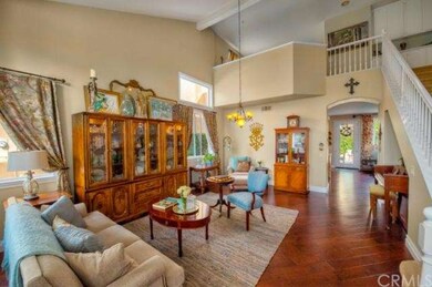 Formal living room with hardwood floor and vaulted