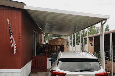 View of parking featuring a carport and a shed