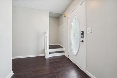 Entryway with baseboards, a textured ceiling, stai