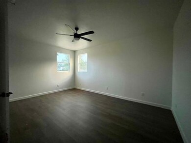 Spare room with a ceiling fan, dark wood-type flo