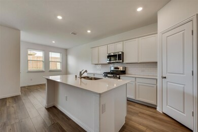 Kitchen with light countertops, appliances with st