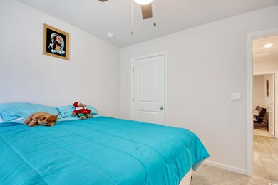 Bedroom featuring light carpet, baseboards, and a 