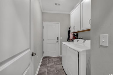 Laundry room with cabinet space, baseboards, visible vents, independent washer and dryer, and crown molding