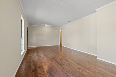 Unfurnished room with ornamental molding, dark wood finished floors, and a textured ceiling