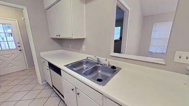 Kitchen featuring light countertops, white cabine