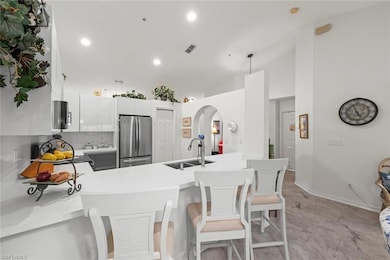 Kitchen featuring a breakfast bar area, white cabinetry, a peninsula, and recessed lighting