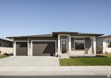 Prairie-style house with driveway, stone siding, a garage, and covered porch