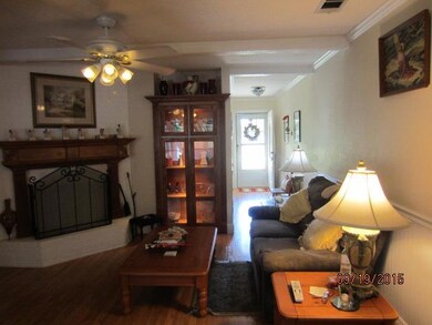 Den, crown molding, ceiling fan and built in curio