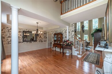 Hardwood floored foyer entrance with a high ceilin