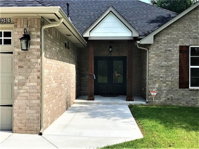 French doors with stunning iron work, 8x8 wood posts, and guttering