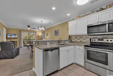 Kitchen with a sink, a peninsula, ornamental molding, and stainless steel appliances
