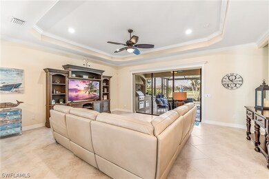 Tiled living room featuring ceiling fan, a raised