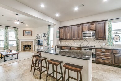 This kitchen will not disappoint!  Your family and guests will enjoy many nights of fun, food and entertainment with ample counterspace and kitchen island for setting up a wonderful array of provisions! This view of this gorgeous kitchen showcases SS appliances, granite countertops, beautiful tile backsplash, gas range oven, high ceiling, recessed lighting and tile floors!