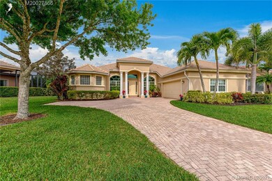 Estate home with paver driveway and columned entry