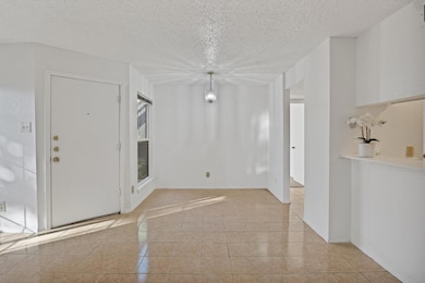 Tiled spare room with an inviting chandelier and a