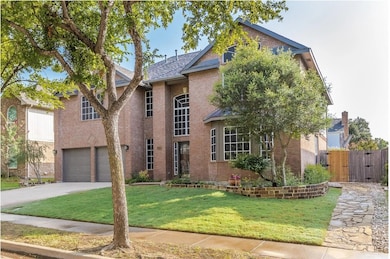 Traditional-style home with brick siding, concrete driveway, and an attached garage