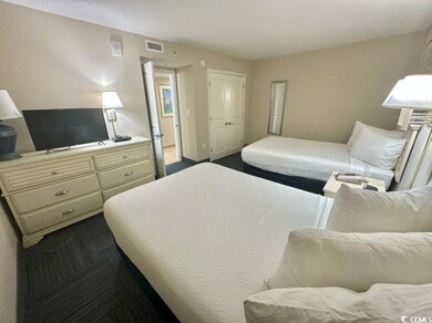 Bedroom featuring dark colored carpet and a closet