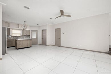 Kitchen with visible vents, a kitchen island, freestanding refrigerator, light countertops, and backsplash