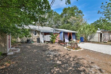 View of rear of home with beautiful covered entertainment area adding extra charm to the rear garden area
