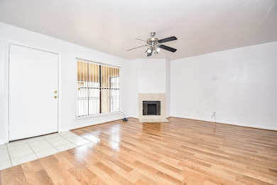 Bright living room with wood floors, a ceiling fan