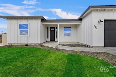 View of front facade with board and batten siding, an attached garage, and a front lawn