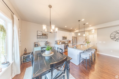 Dining area with dark wood-type flooring, recessed lighting, and a chandelier