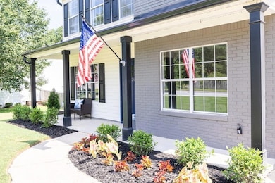 Property entrance with a porch and brick siding