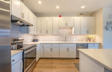 Kitchen with tasteful backsplash, under cabinet ra