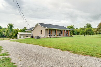 Driveway leads to carport and shop and front yard is spacious