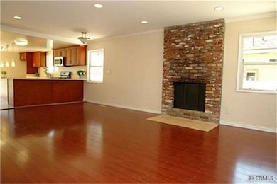 spacious living room opens to kitchen with brick f