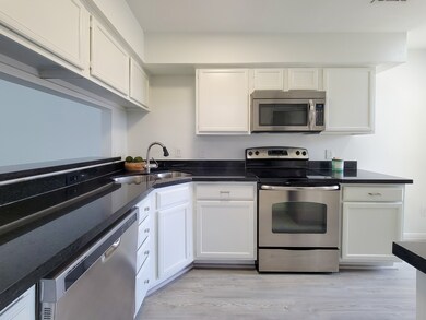 Kitchen features stainless appliances, granite cou