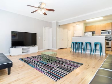 Living area featuring light wood finished floors, ornamental molding, and ceiling fan