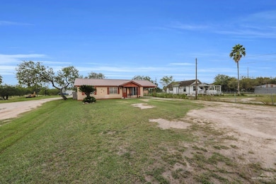 View of front of property featuring driveway, a metal roof, and a front yard