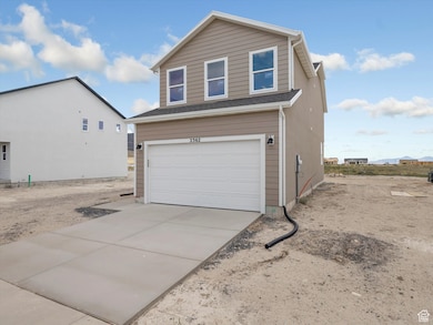 View of side of home featuring driveway and an attached garage