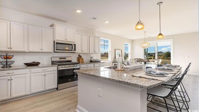 Kitchen with white cabinets, a center island, stai