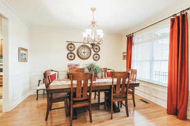 The open dining room is full of natural light, and features wainscoting on the walls. 