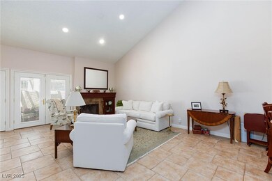 Living area featuring high vaulted ceiling, a fire