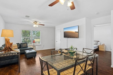 Living area with a ceiling fan, dark wood-style f