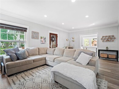 Living room featuring ornamental molding and light hardwood flooring