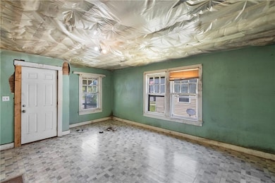 Unfurnished room with tile patterned floors and baseboards