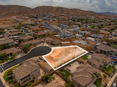 Aerial overview of property's location with property boundaries highlighted, mountains, and nearby suburban area