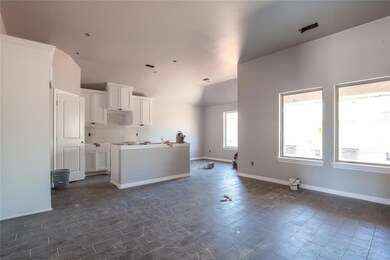 Kitchen with backsplash, dark tile flooring, and w