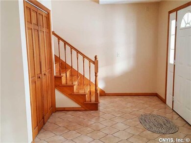 Foyer. Tile entryway and hardwood staircase to sec