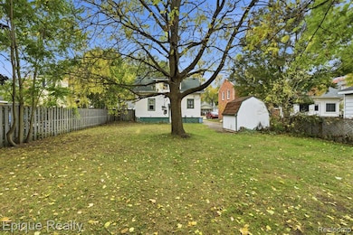 Fenced backyard featuring a storage unit