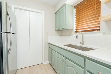 Kitchen featuring a sink, green cabinets, light co