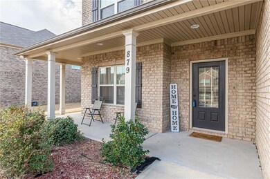 View of exterior entry featuring covered porch and brick siding
